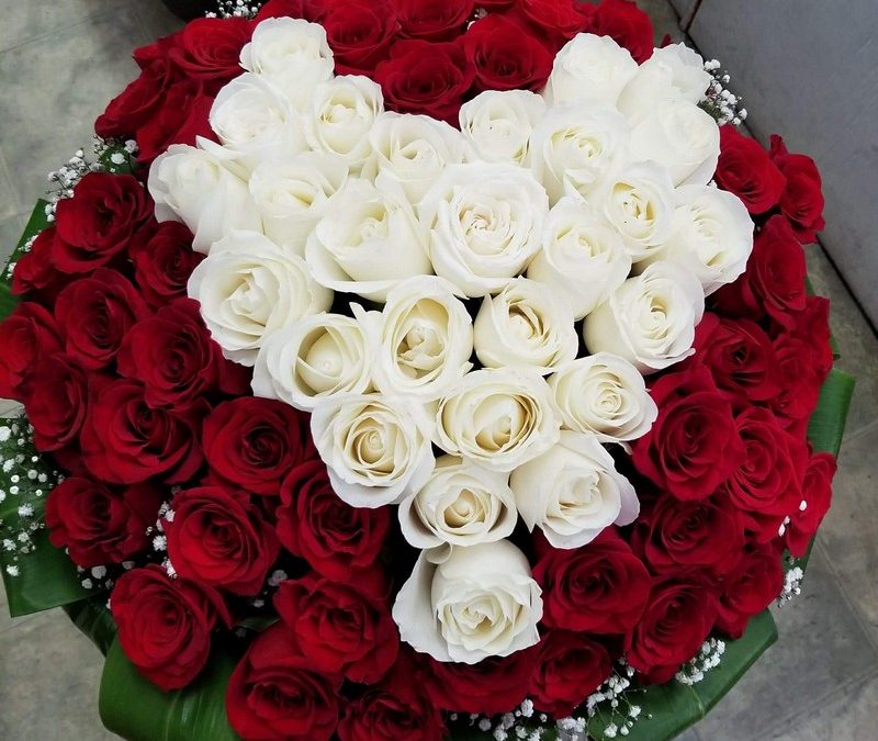 Red rose bouquet with white rose heart arrangement in center.