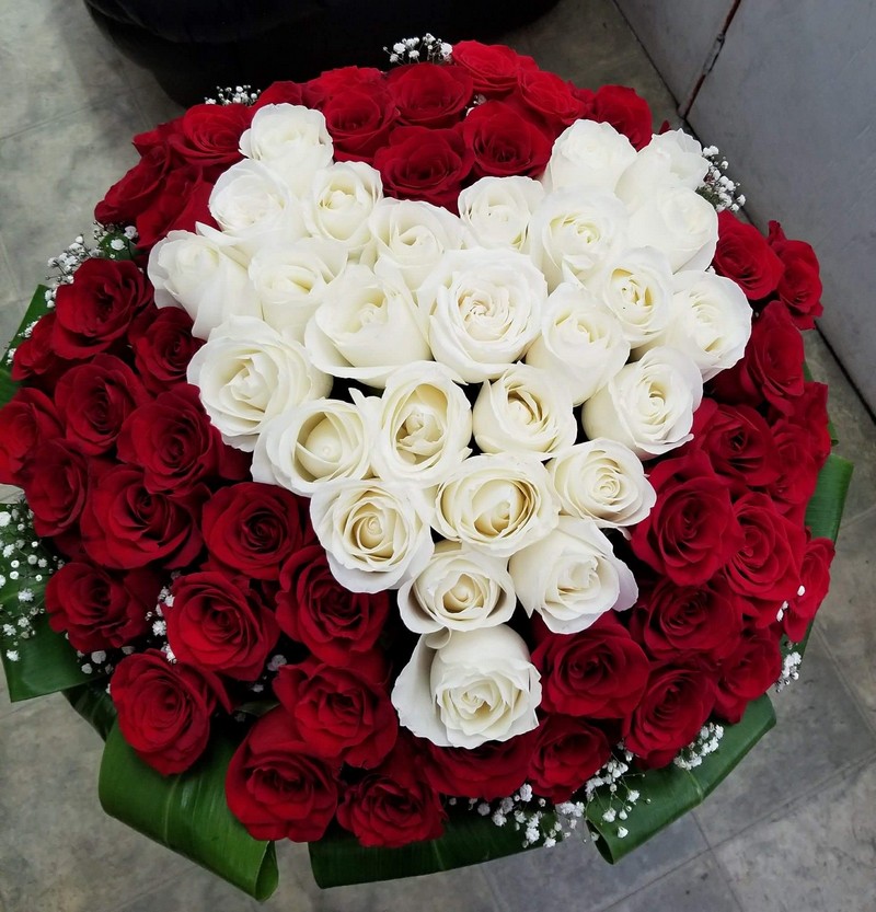 Red rose bouquet with white rose heart arrangement in center.