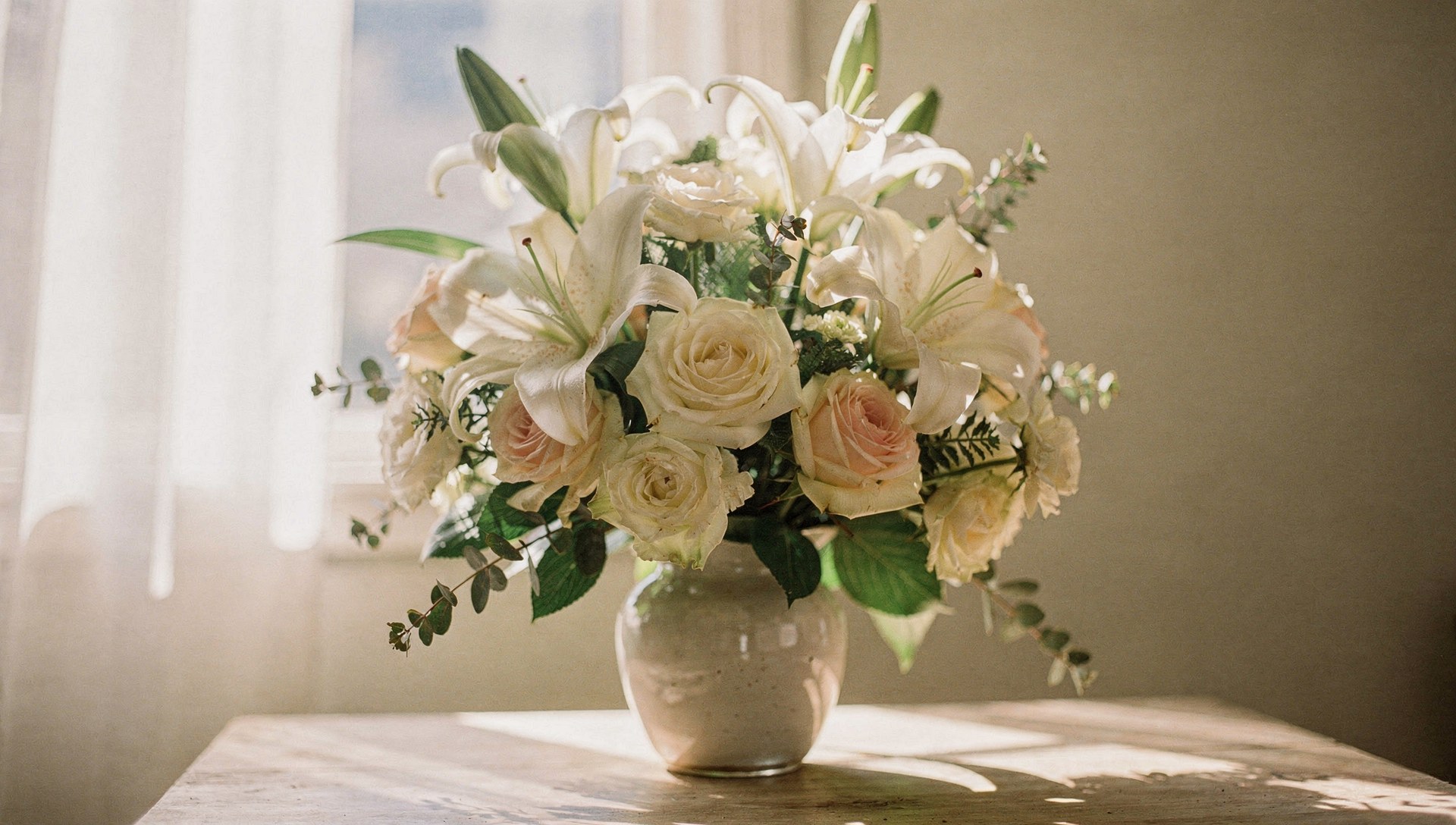 Sympathy flowers San Diego white lily and rose arrangement in soft window light